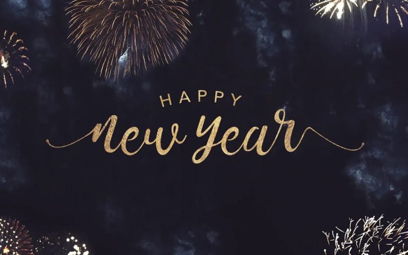 Gold text reading "Happy New Year" is centered against a dark sky background with multiple fireworks bursting around the edges.